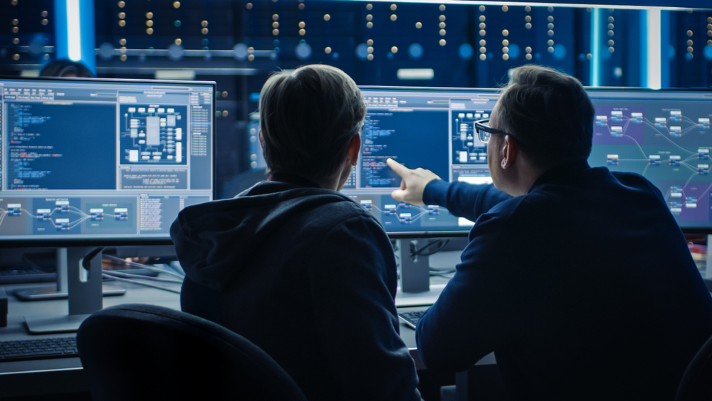 A man pointing at something on a monitor